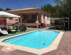 a swimming pool in front of a house at La Casita de Colmenar in Villaconejos