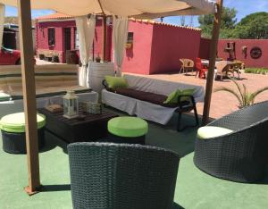 a patio with a couch and chairs under an umbrella at La Casita de Colmenar in Villaconejos