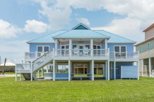 a large blue house with a large deck at Stunning Beachfront Large Deck Sleeps 14 in Caplen