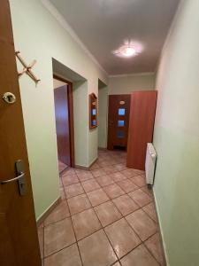 un couloir vide avec une porte et du carrelage dans l'établissement Dom nad Wisłą - pobyty rodzinne, grupowe, terapie, à Wisła