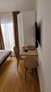a room with a table with a television and a bed at Mirko's home 2 Studio Apartment in Podgorica +3 photos