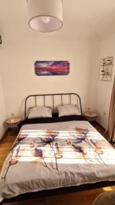a bedroom with a bed with a painting on the wall at Mirko's home 2 Studio Apartment in Podgorica