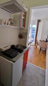 a kitchen with a stove top oven next to a living room at Mirko's home 2 Studio Apartment in Podgorica