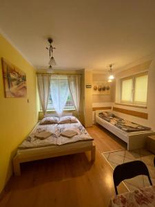 une chambre avec deux lits et une fenêtre dans l'établissement Dom nad Wisłą - pobyty rodzinne, grupowe, terapie, à Wisła 18 autres photos