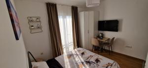 a room with a bed and a table and a television at Mirko's home 2 Studio Apartment in Podgorica