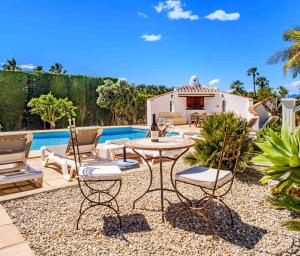 ハベアにあるVilla Llamedos Montgo Javea by Rock Rentalsのプールサイドのパティオ(テーブル、椅子付)