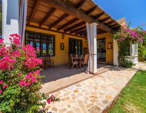 ハベアにあるVilla Abaesko by Rock Rentalsのピンクの花が咲くパティオ付きの家