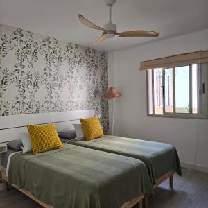 a bedroom with two beds and a ceiling fan at La Casita de Mía in La Restinga +6 photos