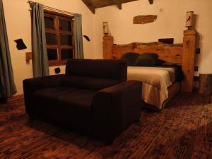 a bedroom with a bed and a couch and a chair at Cedrito in Mineral del Chico +1 photo