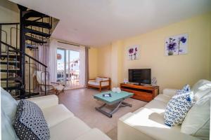a living room with a white couch and a television at Arenal Park II Apartment Javea Arenal by Rock Rentals in Jávea