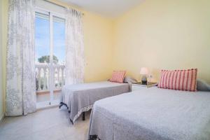 a bedroom with two beds and a large window at Arenal Park II Apartment Javea Arenal by Rock Rentals in Jávea +36 photos