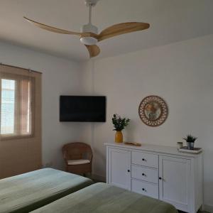 a bedroom with a bed and a ceiling fan at La Casita de Mía in La Restinga
