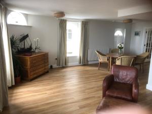 a living room with a table and a chair at Brand new 125 square metre sea view apartment in Deal