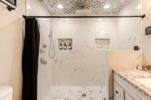 a bathroom with a shower with white marble at Colorful & Cozy 3 Bedroom in Columbus in Columbus +13 photos