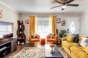 a living room with a yellow couch and orange chairs at Colorful & Cozy 3 Bedroom in Columbus in Columbus