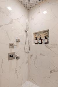 a bathroom with a shower with white marble walls at Colorful & Cozy 3 Bedroom in Columbus in Columbus