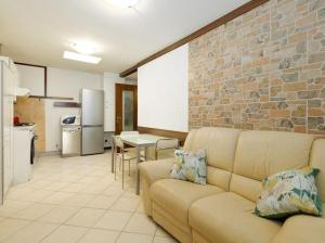 a living room with a couch and a brick wall at IL NIDO DI MASSIMO - a due passi dal centro città in Trieste +4 photos