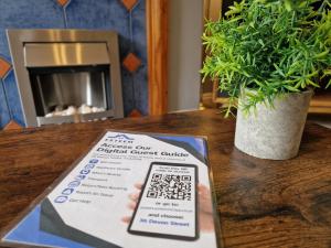 a sign on a table next to a potted plant at Devon St - Cozy home, Free easy parking! in Hull