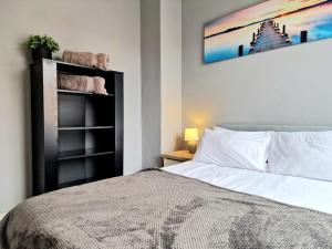 a bedroom with a bed and a picture on the wall at Devon St - Cozy home, Free easy parking! in Hull +24 photos