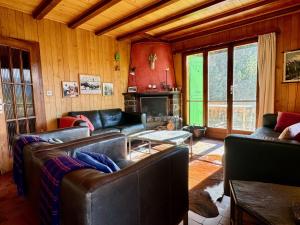 a living room with leather couches and a fireplace at Chalet Christina in Verbier