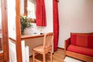 a chair sitting in a room with a mirror and a sink at Résidence Odalys Le Hameau du Borsat in Tignes