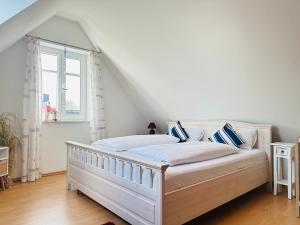 a white bed in a room with a window at Haus Abendsonne in Sankt Peter-Ording