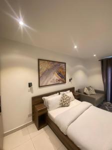 a bedroom with a bed and a painting on the wall at The Lennox at Airport City, Accra in Accra