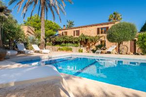 a villa with a swimming pool in front of a house at Finca Can Quadrat by Mallorca House Rent in Caʼs Concos