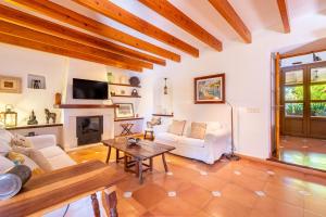 a living room with a couch and a fireplace at Finca Can Quadrat by Mallorca House Rent in Caʼs Concos
