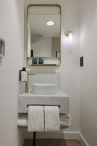 Un baño con lavabo, espejo y toallas. en The Drey, en Londres