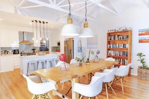 eine Küche und ein Esszimmer mit einem Holztisch und weißen Stühlen in der Unterkunft Fourways Home, Away From Home in Chartwell