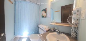Un baño con lavabo, inodoro y espejo. en Petit Hôtel Amara, en La Malbaie