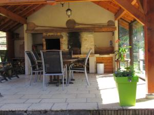 a patio with chairs and a table and a fireplace at Les chalets de Jade in Viremont +47 photos