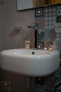 a white sink in a bathroom with a mirror at Dar Naifer in Tozeur +13 photos