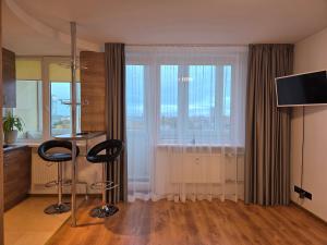 - un salon avec deux tabourets devant une fenêtre dans l'établissement 8th floor panorama studio in Klaipėda - self check in, à Klaipėda