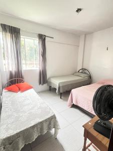 a bedroom with two beds and a window at COP 30, Mosqueiro - Apto pé na areia in Belém