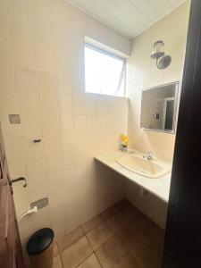 a white bathroom with a sink and a window at COP 30, Mosqueiro - Apto pé na areia in Belém +15 photos