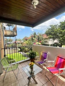a patio with chairs and a table and a balcony at COP 30, Mosqueiro - Apto pé na areia in Belém