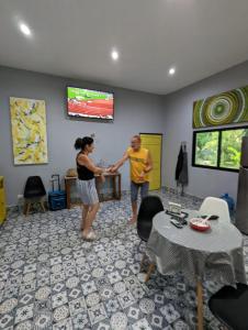 a man and a woman shaking hands in a living room at The Blue Eco Lodge in Valladolid