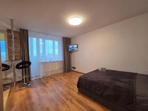 une chambre avec un lit et une télévision à écran plat dans l'établissement 8th floor panorama studio in Klaipėda - self check in, à Klaipėda 5 autres photos