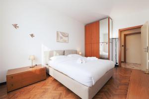 een slaapkamer met een groot wit bed en een spiegel bij Primopiano - Corsica in Milaan