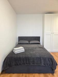a bedroom with a bed with a gray blanket at Panorama studio in Klaipėda - self check in in Klaipėda