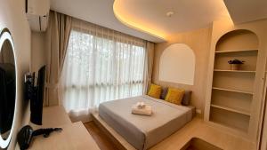 Un dormitorio pequeño con una cama y una ventana. en Fantasea Kamala Beach 1 BR 411, en Kamala Beach