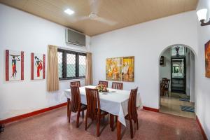 ein Esszimmer mit einem weißen Tisch und Stühlen in der Unterkunft Omni Holiday Bungalow in Mount Lavinia