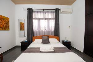 ein Schlafzimmer mit großem Bett und Fenster in der Unterkunft Omni Holiday Bungalow in Mount Lavinia