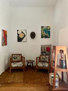 a room with two chairs and a table and paintings at Atlas Mountains Retreat in Ouirgane
