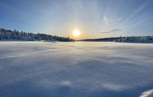a large snow covered field with the sun in the background at Amazing Home In Gålå With Sauna in Gålå +15 photos