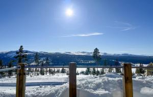 a snow covered hill with a fence and mountains at Amazing Home In Gålå With Sauna in Gålå