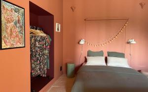 a bedroom with a bed with orange walls at Òli - chambre d'hôtes coeur de village à Roquecor, 2 personnes in Roquecor +14 photos