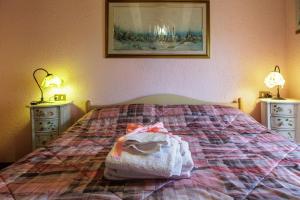 een slaapkamer met een bed met 2 nachtkastjes en een foto bij Chalet Orchidea in Gallio +11 foto's